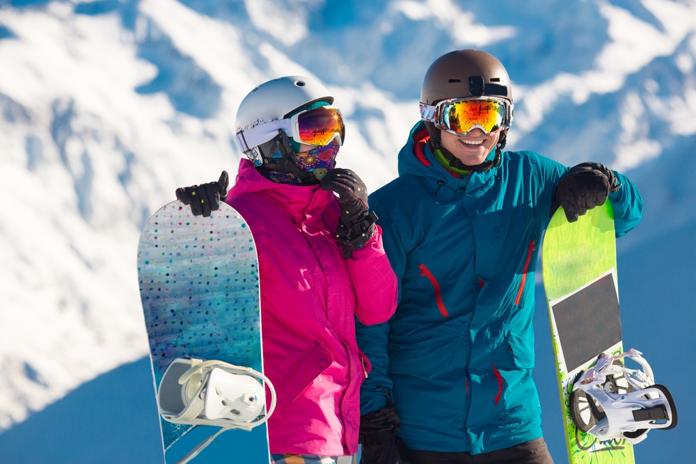 Best Skiing In Oregon: couple holding their snowboards on a snowy day on Mount Hood 